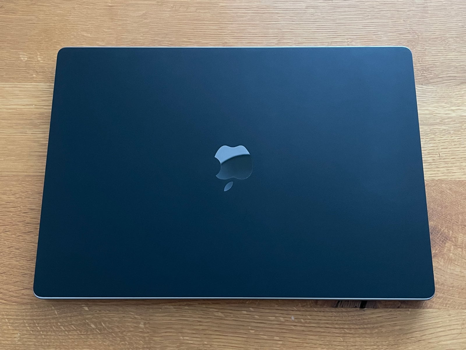 閉じた状態のMacBook Pro 16インチ。ほぼ真上の正面手前から撮った写真。Appleロゴ部分には切り抜きが入っているため綺麗に反射している